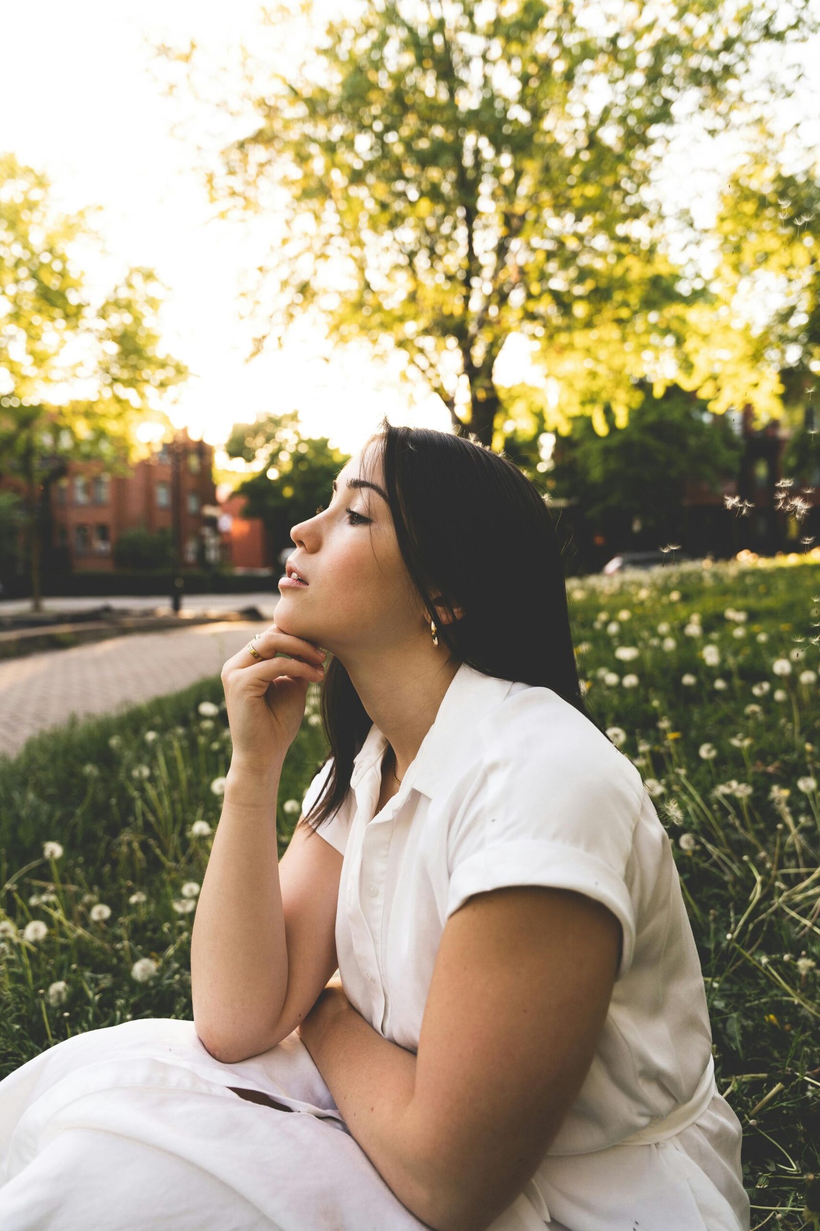 Woman enjoying a serene moment in a Montreal park during golden hour, surrounded by nature.